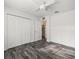 Bedroom features gray plank floors, fan, and a closet at 15430 Oakcrest Cir, Brooksville, FL 34604
