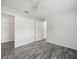 Bedroom featuring gray hardwood floors, a walk-in closet, and a ceiling fan at 15430 Oakcrest Cir, Brooksville, FL 34604