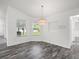 Bright dining room with wood-look floors, neutral walls, and modern light fixture at 15430 Oakcrest Cir, Brooksville, FL 34604