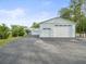 View of detached garages, driveway, lush lawn and mature landscaping at 15430 Oakcrest Cir, Brooksville, FL 34604