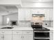 Stylish kitchen featuring white cabinets, quartz countertops, and stainless steel appliances at 15430 Oakcrest Cir, Brooksville, FL 34604