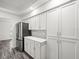 New kitchen with stainless steel refrigerator, white cabinets, and light backsplash at 15430 Oakcrest Cir, Brooksville, FL 34604