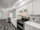 Modern kitchen with stainless steel appliances, white cabinets, and stylish backsplash at 15430 Oakcrest Cir, Brooksville, FL 34604