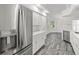 Modern kitchen with stainless refrigerator, white cabinets, and wood-look floors at 15430 Oakcrest Cir, Brooksville, FL 34604