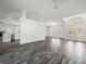Open floor plan living area with wood-look floors, modern lighting, and bright entry at 15430 Oakcrest Cir, Brooksville, FL 34604