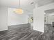 Spacious living room features wood-look floors and modern lighting fixture at 15430 Oakcrest Cir, Brooksville, FL 34604