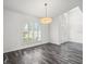 Bright living room with wood-look floors, pendant lighting and a large arched window at 15430 Oakcrest Cir, Brooksville, FL 34604