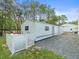 Exterior of outbuilding on a gravel lot with a fenced-in side yard at 15430 Oakcrest Cir, Brooksville, FL 34604
