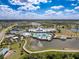 Stunning aerial view of a resort-style community clubhouse with a pool, tennis courts, and lush landscaping at 18743 W Coastal Shore Ter, Land O Lakes, FL 34638