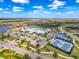 Aerial view of the community center with pool, tennis courts, and parking, surrounded by lush landscaping and scenic views at 18743 W Coastal Shore Ter, Land O Lakes, FL 34638
