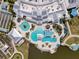 An aerial view of the community clubhouse with multiple pools, lounge areas, and manicured landscaping at 18743 W Coastal Shore Ter, Land O Lakes, FL 34638