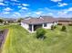 Aerial view of backyard with lake, lush lawn, and screened patio at 18743 W Coastal Shore Ter, Land O Lakes, FL 34638