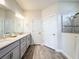 Bathroom featuring double sinks, a spacious vanity, and a glass-enclosed shower at 18743 W Coastal Shore Ter, Land O Lakes, FL 34638