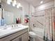 Bright bathroom features a single sink vanity, tub with shower, and flamingo-themed shower curtain at 18743 W Coastal Shore Ter, Land O Lakes, FL 34638