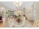 Formal dining room features a glass table, white chairs, and a modern chandelier at 22850 Skyview Cir, Brooksville, FL 34602