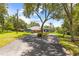 Well-maintained single-story home with mature trees and a circular driveway leading to the three-car garage at 22850 Skyview Cir, Brooksville, FL 34602