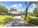 Charming single-story home featuring a well-manicured lawn, mature trees, and a three-car garage at 22850 Skyview Cir, Brooksville, FL 34602
