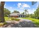 Beautiful single-story home with a lush lawn, mature landscaping, and a long driveway leading to the three-car garage at 22850 Skyview Cir, Brooksville, FL 34602