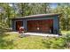 Detached two-car garage with wooden doors providing additional storage space and convenience at 22850 Skyview Cir, Brooksville, FL 34602