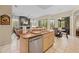 The open kitchen has stainless appliances and a sink in the island with a view of the living room at 22850 Skyview Cir, Brooksville, FL 34602
