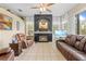 Cozy living room featuring a fireplace, tile floors, and comfortable leather furniture at 22850 Skyview Cir, Brooksville, FL 34602