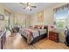 Primary bedroom with ceiling fan, wood-look flooring, rocking chair, and dresser at 22850 Skyview Cir, Brooksville, FL 34602