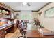 Detailed view of an office featuring a wooden desk, leather chair, and natural light at 22850 Skyview Cir, Brooksville, FL 34602