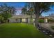 Charming home exterior with manicured lawn, stone accents, and mature trees, showcasing curb appeal and inviting landscape at 2295 Rio Cir, Spring Hill, FL 34608