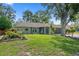 Charming single-story home featuring stone accents, lush landscaping, and an attached two-car garage at 2295 Rio Cir, Spring Hill, FL 34608
