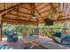 Spacious gazebo interior featuring comfortable seating, ceiling fan, TV, and stylish decor, ideal for outdoor entertaining at 2295 Rio Cir, Spring Hill, FL 34608