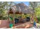 Inviting thatched-roof gazebo with deck, offering a relaxing outdoor living space with ample seating and views of lush surroundings at 2295 Rio Cir, Spring Hill, FL 34608