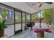 Cozy screened patio with a grill, table, and chairs, perfect for outdoor dining and relaxation at 2295 Rio Cir, Spring Hill, FL 34608