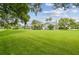 Lush backyard featuring well-maintained lawn and landscaping with a screened-in lanai at 2519 Shipston Ave, New Port Richey, FL 34655