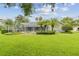 Lush backyard featuring well-maintained lawn and landscaping with a screened-in lanai at 2519 Shipston Ave, New Port Richey, FL 34655