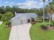 Aerial view showcasing the home's facade, three-car garage, landscaped front yard, and long driveway at 2519 Shipston Ave, New Port Richey, FL 34655