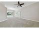 Spacious living room with carpet, sliding glass doors to the pool, and neutral decor at 2519 Shipston Ave, New Port Richey, FL 34655