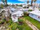 Aerial view of a home with solar panels amid lush palm trees and neighboring homes at 336 Boca Ciega Dr, Madeira Beach, FL 33708