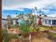 Exterior view of a single-story home with brick accents and flourishing tropical foliage at 336 Boca Ciega Dr, Madeira Beach, FL 33708