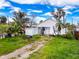 A home featuring a tropical landscape, a small storage shed, and a gravel driveway at 336 Boca Ciega Dr, Madeira Beach, FL 33708