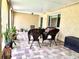 Serene back porch featuring brick floors, a seating arrangement, and a variety of potted plants at 3447 Paloma Dr, Holiday, FL 34690