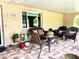 Cozy back porch with brick pavers, comfortable seating, and a relaxing outdoor ambiance at 3447 Paloma Dr, Holiday, FL 34690