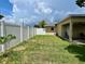 Well-maintained backyard enclosed by a white fence and a view of the covered patio at 3447 Paloma Dr, Holiday, FL 34690