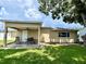 Spacious backyard with a covered patio, a table and chair set, and a large shade tree at 3447 Paloma Dr, Holiday, FL 34690