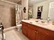 Well-lit bathroom featuring a vanity with wooden cabinets and a shower with decorative tile surround at 3447 Paloma Dr, Holiday, FL 34690