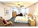 Well-lit bedroom features a ceiling fan, comfortable sleeping arrangements, and cozy sitting area at 3447 Paloma Dr, Holiday, FL 34690