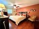 Inviting bedroom features hardwood floors, warm lighting, and comfortable sleeping arrangements at 3447 Paloma Dr, Holiday, FL 34690