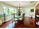 Well-lit dining area featuring a glass-top table, hardwood floors, and a large window at 3447 Paloma Dr, Holiday, FL 34690