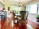 A dining area with hardwood floors, a chandelier, and a glass table at 3447 Paloma Dr, Holiday, FL 34690