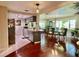 View of the dining area with a chandelier, hardwood floors, and large windows providing natural light at 3447 Paloma Dr, Holiday, FL 34690
