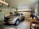 Spacious garage featuring a car, work bench, and shelving units for storage at 3447 Paloma Dr, Holiday, FL 34690